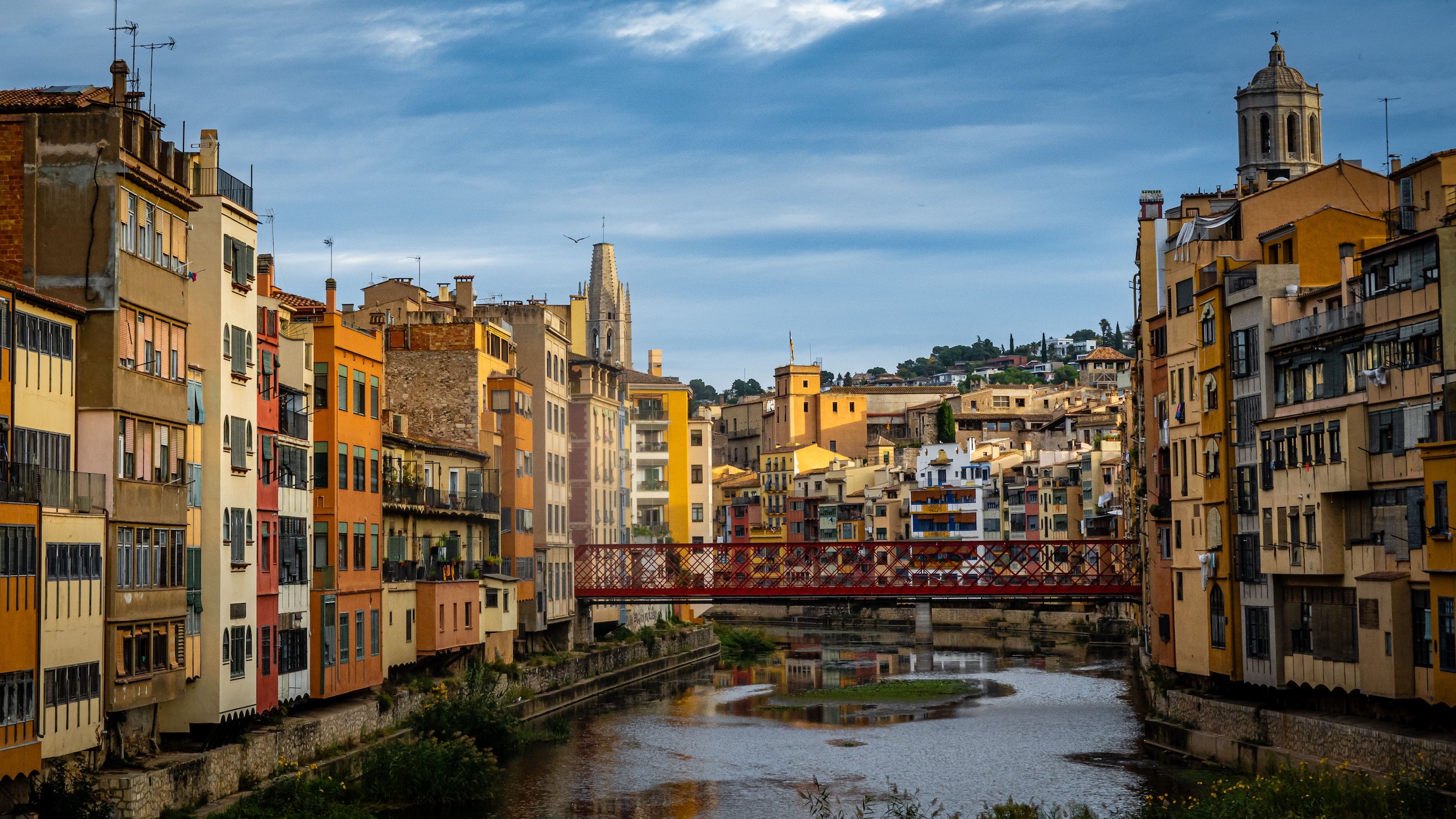 The Onyar riverfront in Girona, medieval houses reflecting in still water